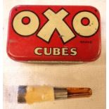 An Oxo tin containing an amber, white metal and bone cheroot holder