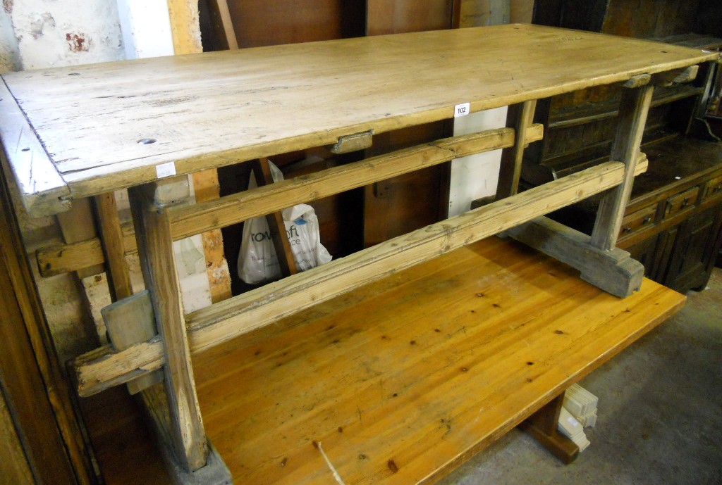 A 6' 1" antique French pine kitchen table, set  on twin flanking pegged supports