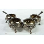 A set of four Victorian silver salts with parcel gilt interiors and embossed festoon, set on shell