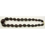 A dark red amber graduated bead necklace with barrel clasp