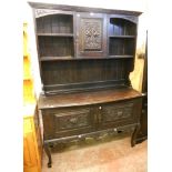 A 4' 6" Victorian stained oak two part dresser, with central cupboard enclosed by a carved panel