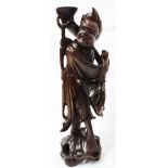 A 17" carved wood figure of an Oriental man carrying a standard - table lamp base