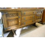 A 5' 4" Old Charm polished oak sideboard with three central drawers and flanking foliate and linen