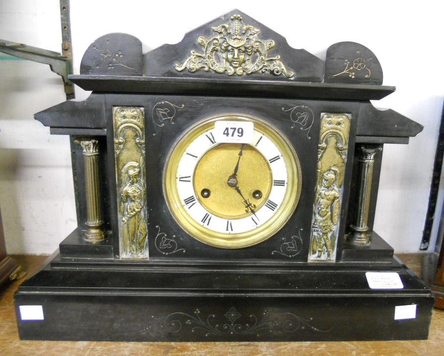 A late Victorian black slate cased mantel clock of architectural design, with flanking Corinthian