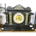 A late Victorian black slate cased mantel clock of architectural design, with flanking Corinthian