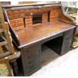 A 5' late Victorian stained oak double pedestal roll top desk, with tambour enclosing a fully fitted