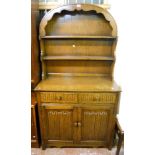 A 3' 1" oak dome top dresser with two shelf open plate rack, over two short drawers and pair of