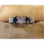 An 18ct. gold ring set with three diamonds interspersed with two sapphires