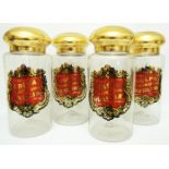 A set of four cylindrical apothecary's glass jars, with gilt domed tops and printed and gilded