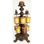 A late Victorian sewing bobbin stand, with pin cushion finial to top and ornate cast iron base