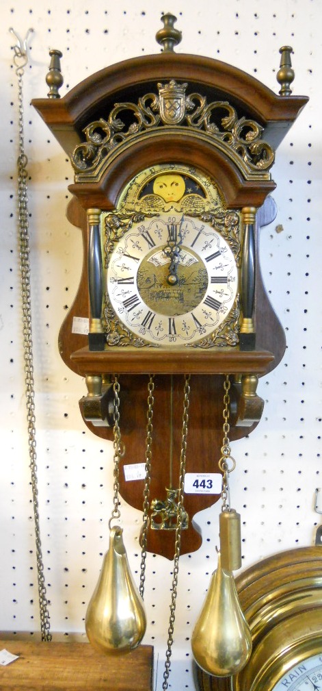 A reproduction mahogany cased ornate wall clock, with moon phase and twin brass plumb bob driven