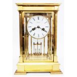 A 11 1/2" Rapport brass and four bevelled glass library clock, with Roman numerals to white dial,