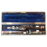 A rosewood flute in a leather clad fitted case