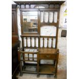 A 4' 2" early 20th Century oak hall stand, with bevelled mirror, moulded slats, glove drawer and