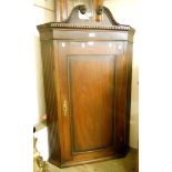 A 31" early 19th Century mahogany and cross banded hanging corner cupboard, with swan neck pediment,