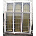 A set of four rectangular window frames containing three stained glass Gothic style arches,