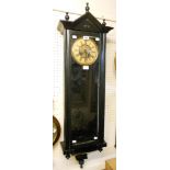 An ebonised cased wall clock, with large visible pendulum and spring driven gong striking movement