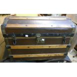 A 27" vintage pressed metal and wooden bound dome top travelling trunk