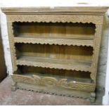 A 4' 3" 19th Century continental limed oak plate rack, with carved decoration to front, two open