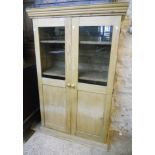 A 3' 3" waxed pine cabinet with moulded cornice, shelves enclosed by a pair of part glazed