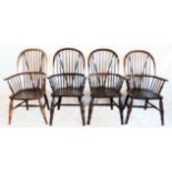 A set of four comb-back Windsor elbow chairs with solid elm seats, set on ring turned legs
