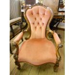 A Victorian walnut framed button back boudoir elbow chair with acanthus carved decoration to top