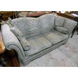 A Knole two seater settee with green jacquard fabric upholstery, braided rope tassels, bolster and