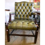 An Edwardian stained wood framed green leather button back upholstered elbow chair, set on square