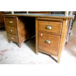 A 4' 7" mid 20th Century oak twin pedestal desk, with flanking slides, drawers and tilting file