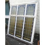 A set of four rectangular window frames containing three stained glass Gothic style arches,