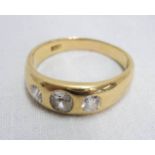 An 18ct. gold three stone diamond ring - size X