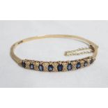 A 9ct. gold bracelet, set with nine graduated sapphires interspersed with diamonds