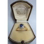 An 18ct. gold ring set with central sapphire within and old cut diamond border