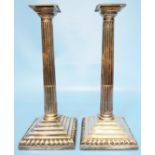 A pair of 11½" silver corinthian column candlesticks, with detachable nozzles, set on stepped and