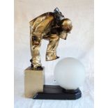 A 1930s plaster table lamp in the form of Pierrot holding his head, with opaque spherical glass