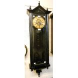An ebonised cased wall clock, with large visible pendulum and spring driven gong striking movement
