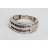 A 10k. white gold ring set with two rows of small diamonds