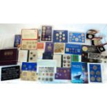 A case containing a quantity of coin sets, including several 1970 pre-decimal, GB crowns, New