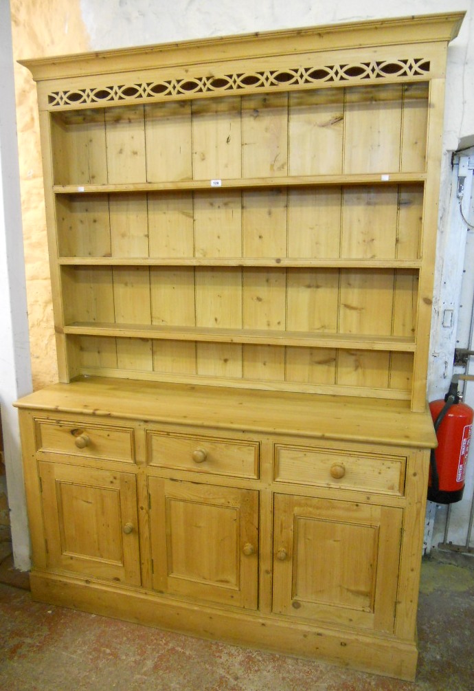 A 5' 2" waxed pine dresser, with moulded and pierced cornice to three shelf open plate rack, over