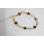 A 9ct. gold fancy link bracelet, set with alternating smoky quartz stones