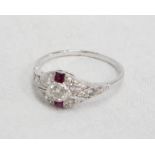An Art Deco style 18ct. white gold ring, set with central diamond, flanking rubies and diamond