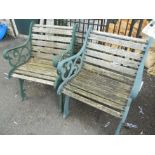 A pair of cast iron framed garden chairs with slatted backs and seats