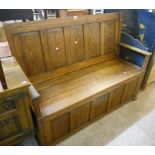 A 4' 10" oak bench with panelled back and locker seat