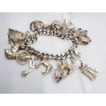 A silver charm bracelet, set with numerous silver and white metal charms, silver heart shaped
