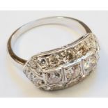 An Art Deco style 18ct. white gold ring, set with three central diamonds within a diamond