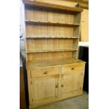 A 4' 10" Victorian pine dresser with three shelf open plate rack, over a base with two frieze