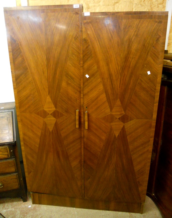 A 3' 11" Art Deco geometric walnut veneered double wardrobe with stepped top, fitted interior and