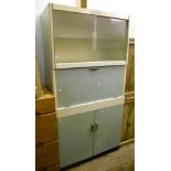 A 35" mid 20th Century Eastham kitchen unit with glazed top, fall front and pair of glazed