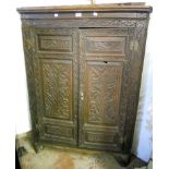 A 3' 3" antique continental carved oak corner cupboard, with scalloped shelves enclosed by a pair of