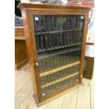 An early 20th Century stained wood cabinet with later fitted rack interior and enclosed by a